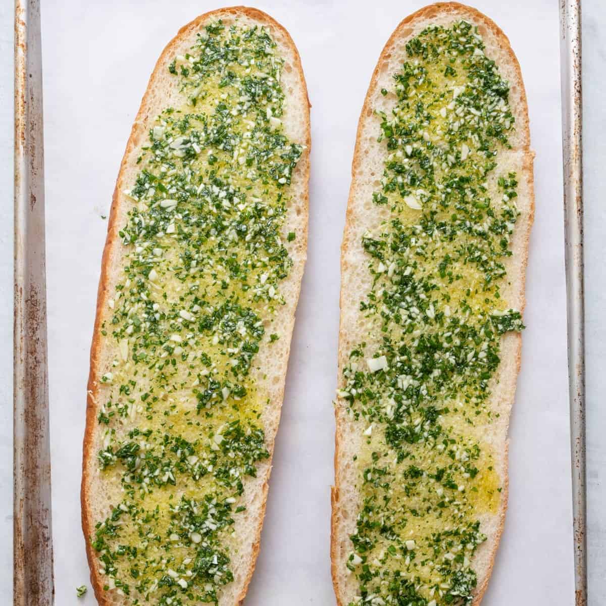 Garlic and herb mixture spread across the bread. 