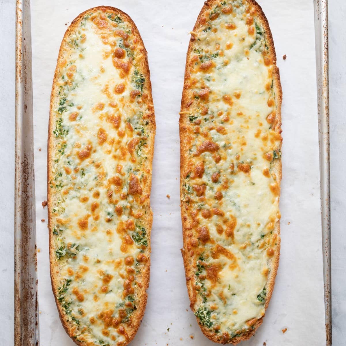 The melted cheese is bubbling on the bread after baking. 