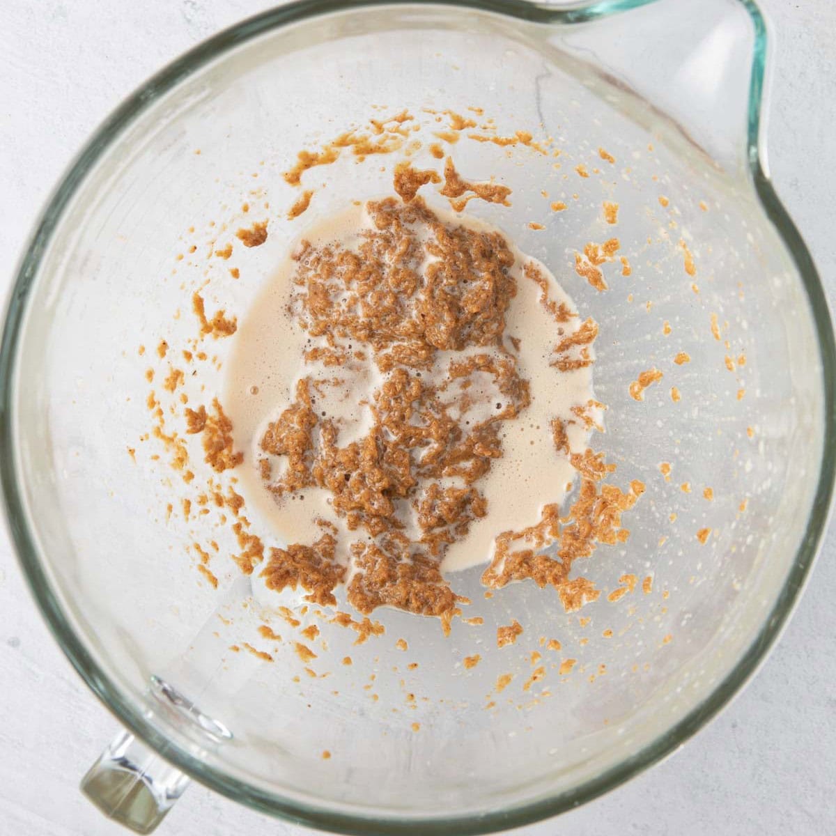 Almond butter, honey and oil after mixed showing slightly foamy mixture.