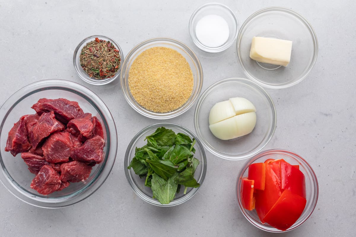 Ingredients for recipe before prepping: lean chuck beef, spices, bulgur, basil and mint, onion, salt, butter, and red pepper.