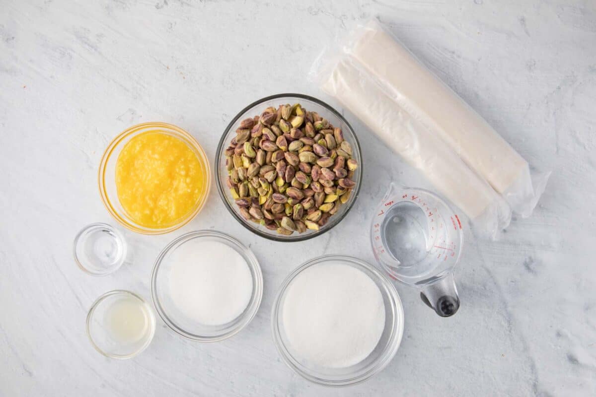 Ingredients for recipe before prepping: pistachios, melted ghee, phyllo, sugar, water, lemon juice, and orange blossom water.