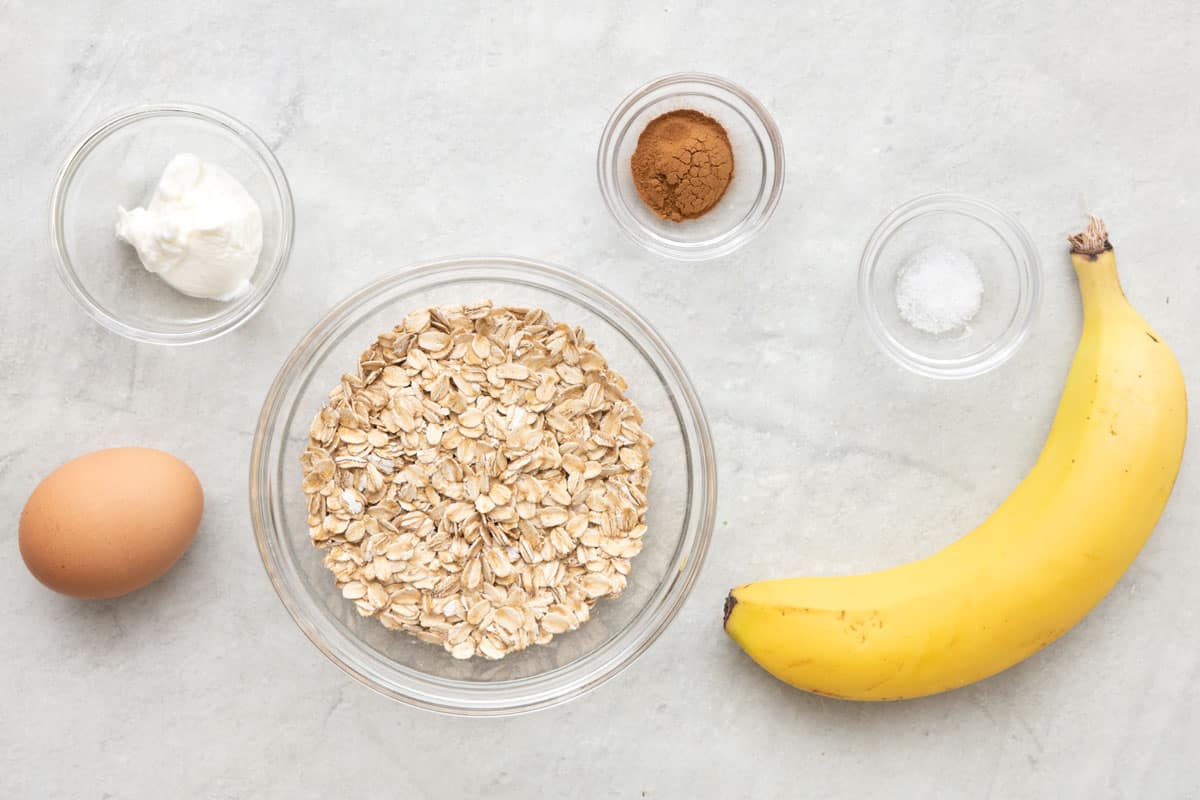 Ingredients for recipeL yogurt, egg, oats, cinnamon, salt, and a banana.