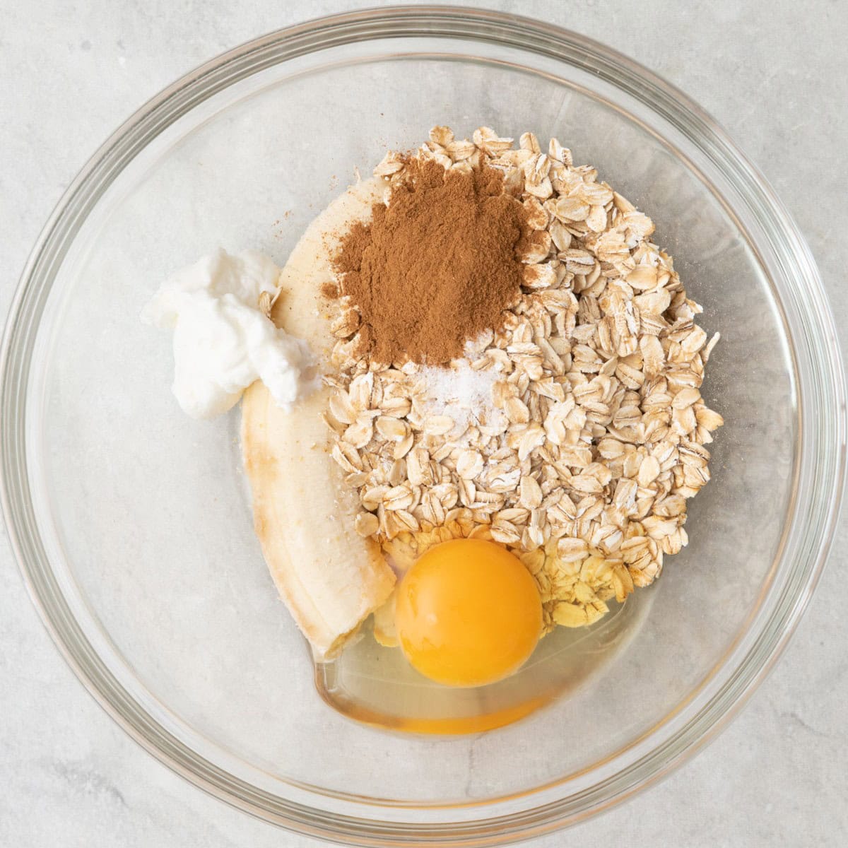 Banana, oats, egg, yogurt, cinnamon and salt in a large bowl before mixing.