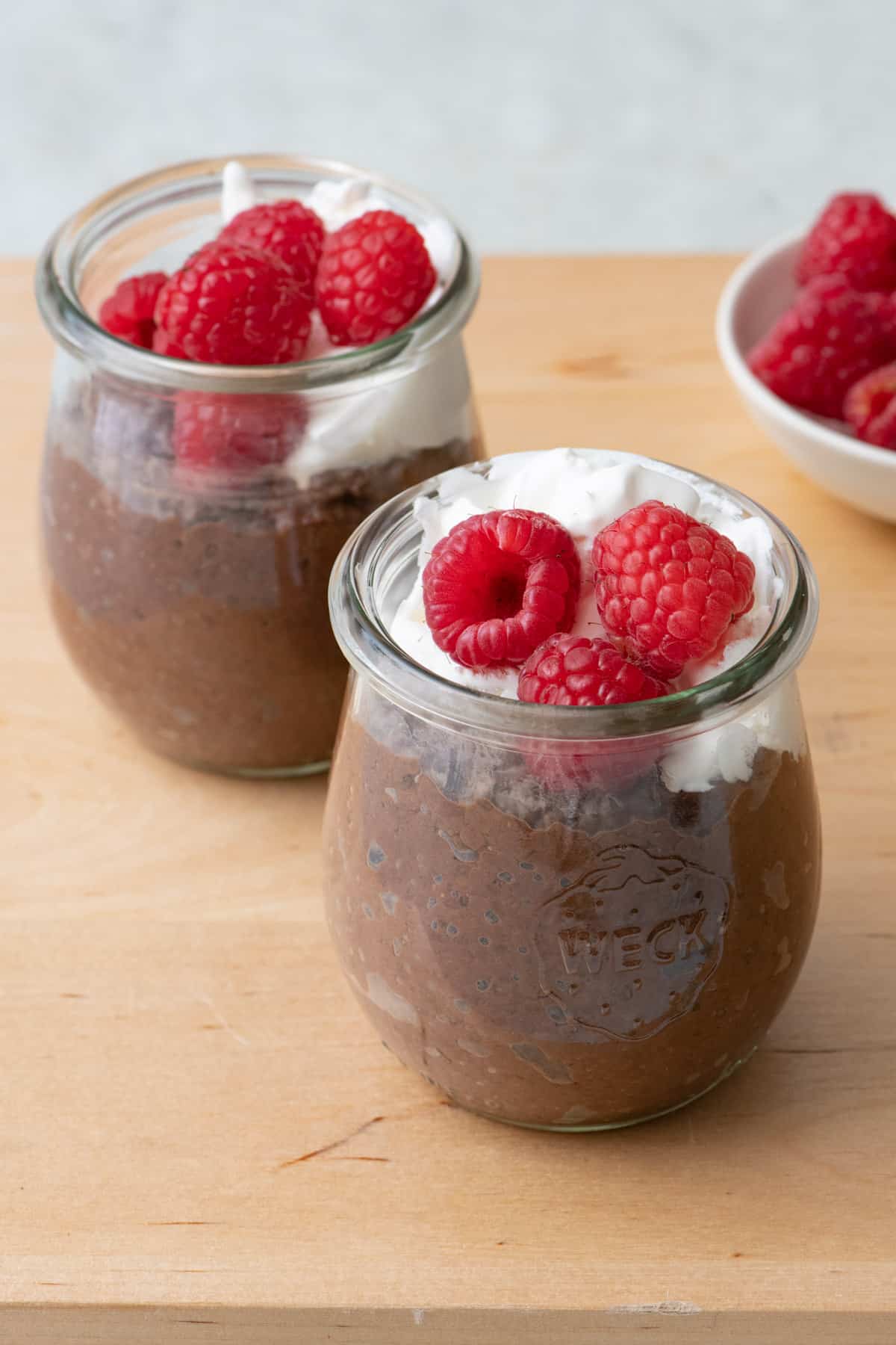 Close up of two glass jars of chocolate pudding