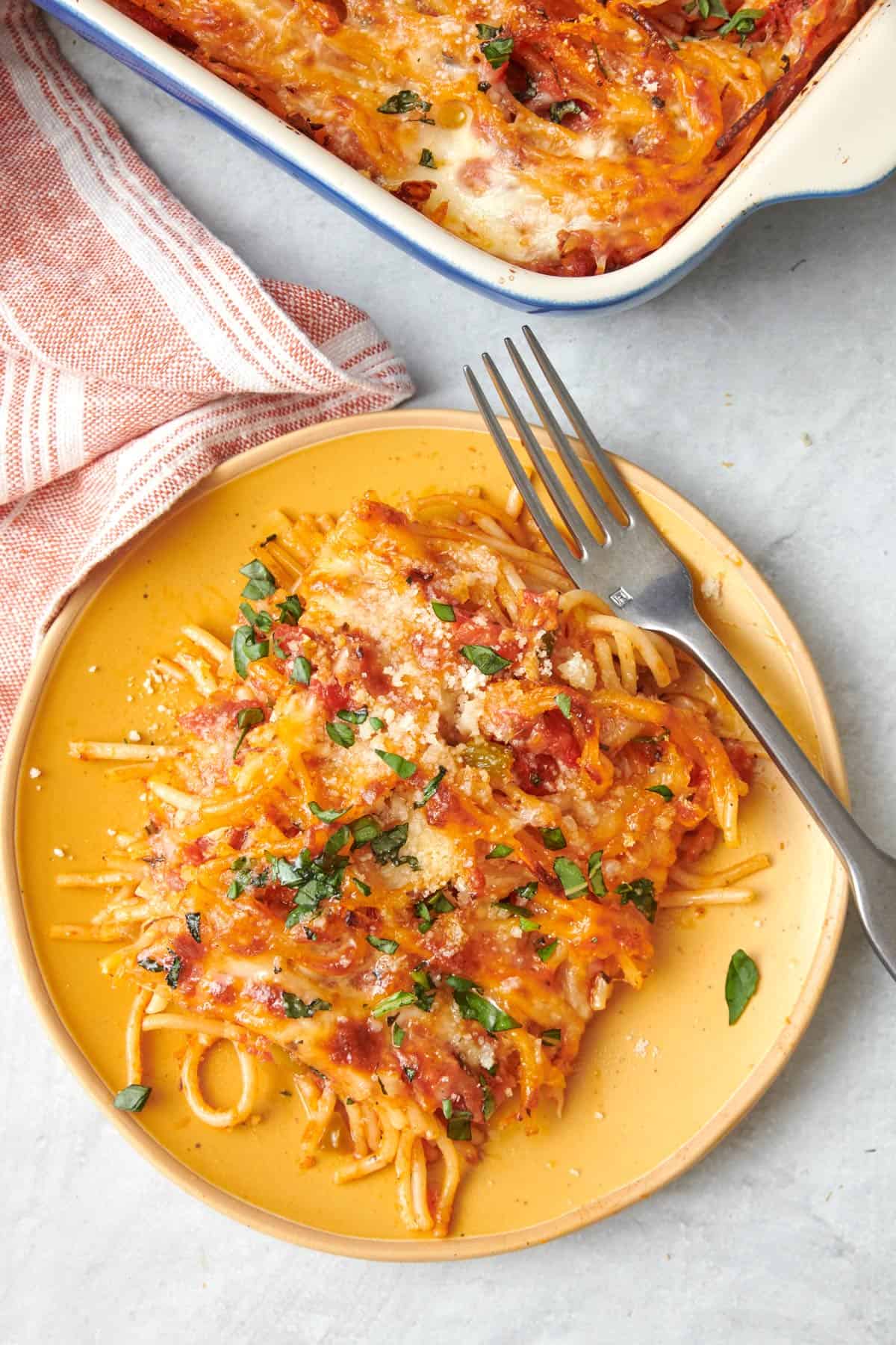 Two bowls of easy baked spaghetti topped with basil leaves