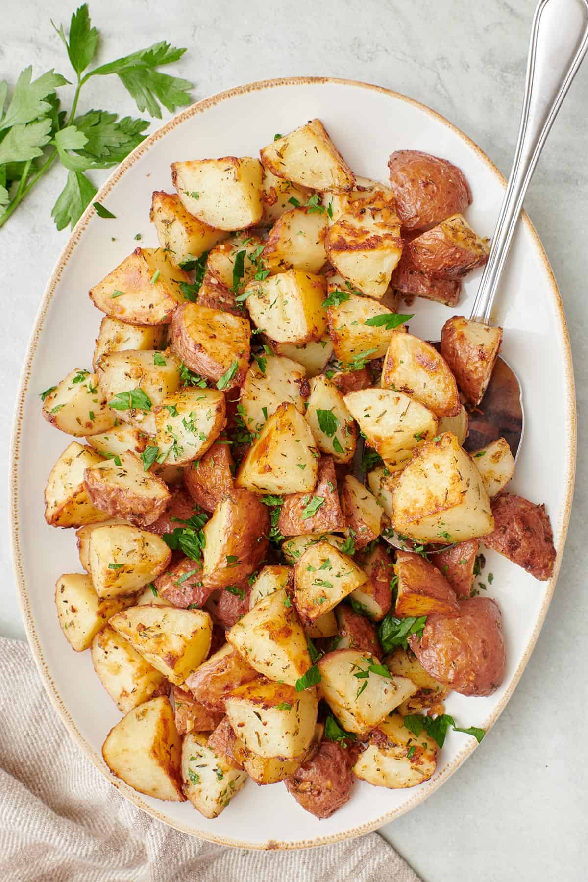 Long serving dish of garlic roasted potatoes served with cilantro