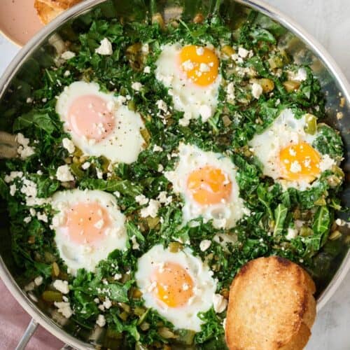 Green Shakshuka cooked in a large skillet.