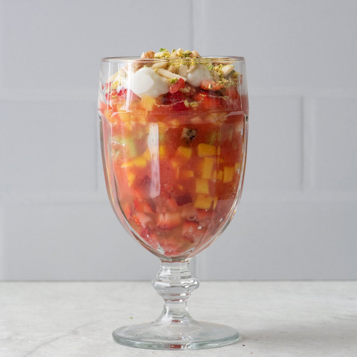 Dollop of ashta added on top with almonds, walnuts, and pistachios on top.