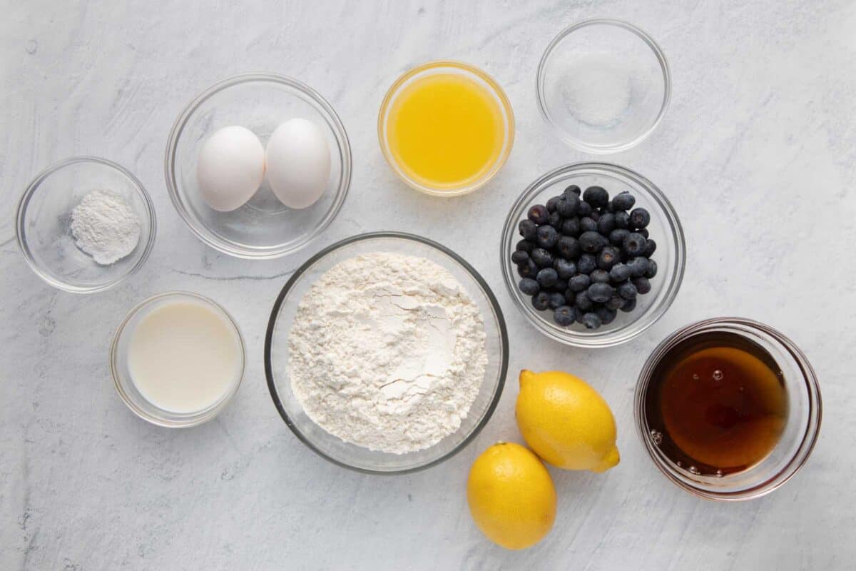 Ingredients for recipe: baking powder, milk, eggs, melted butter, flour, salt, blueberries, lemons, and maple syrup.
