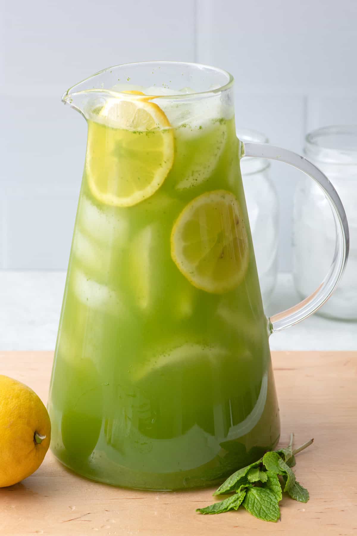 Pitcher of mint lemonade with fresh lemon slices.
