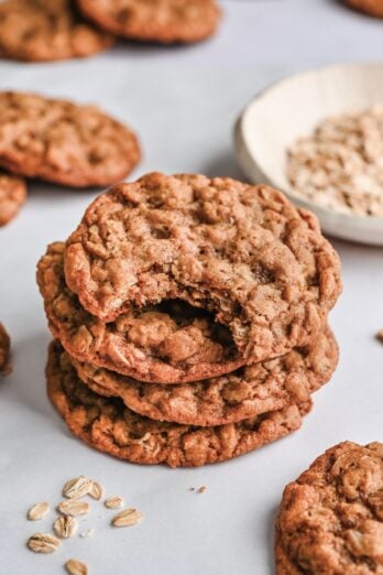 Stack of 3 oatmeal cookies with more nearby.