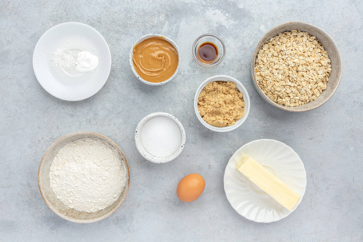 Ingredients for recipe before baking: Butter, granulated sugar, brown sugar, egg, peanut butter, vanilla extract, all-purpose flour, baking soda, salt, and old-fashioned oats