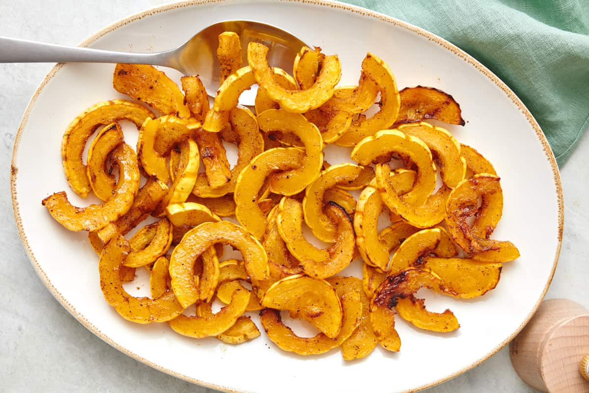 Roasted delicata squash slices on a large oval platter.