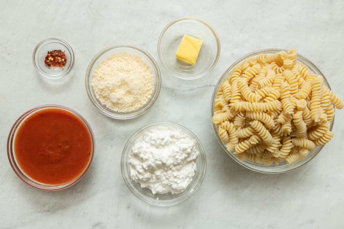 Ingredients for recipe: marinara, parmesan cheese, cottage cheese, red pepper flakes, butter, and cooked pasta.