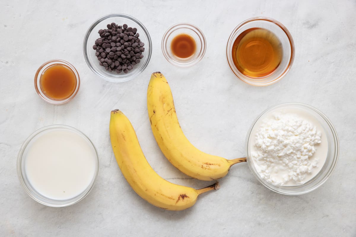 Ingredients for recipe: caramel syrup, milk, chocolate chips, 2 bananas, vanilla extract, maple syrups, and collage cheese.