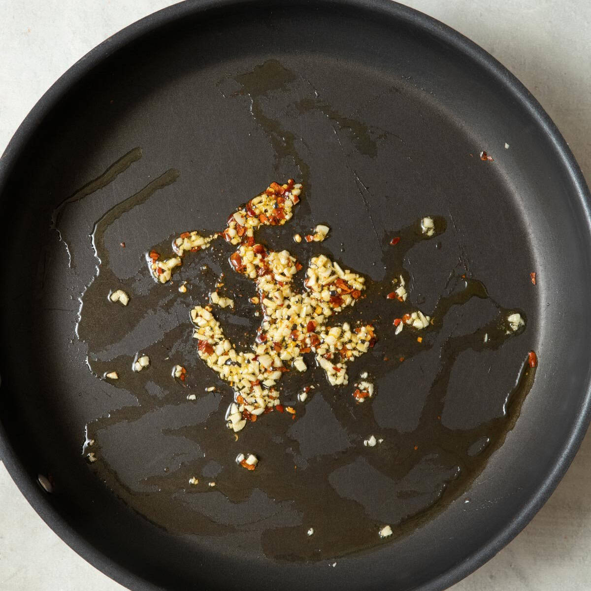 Oil, garlic, and red pepper flakes in a large deep skillet.