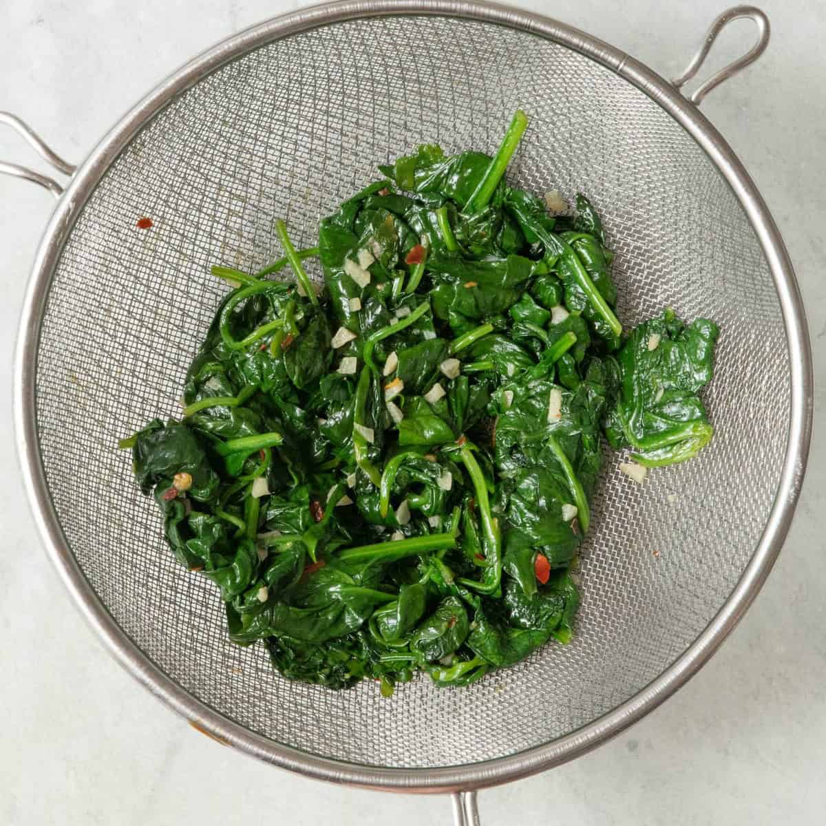 Spinach mixture in a strainer.