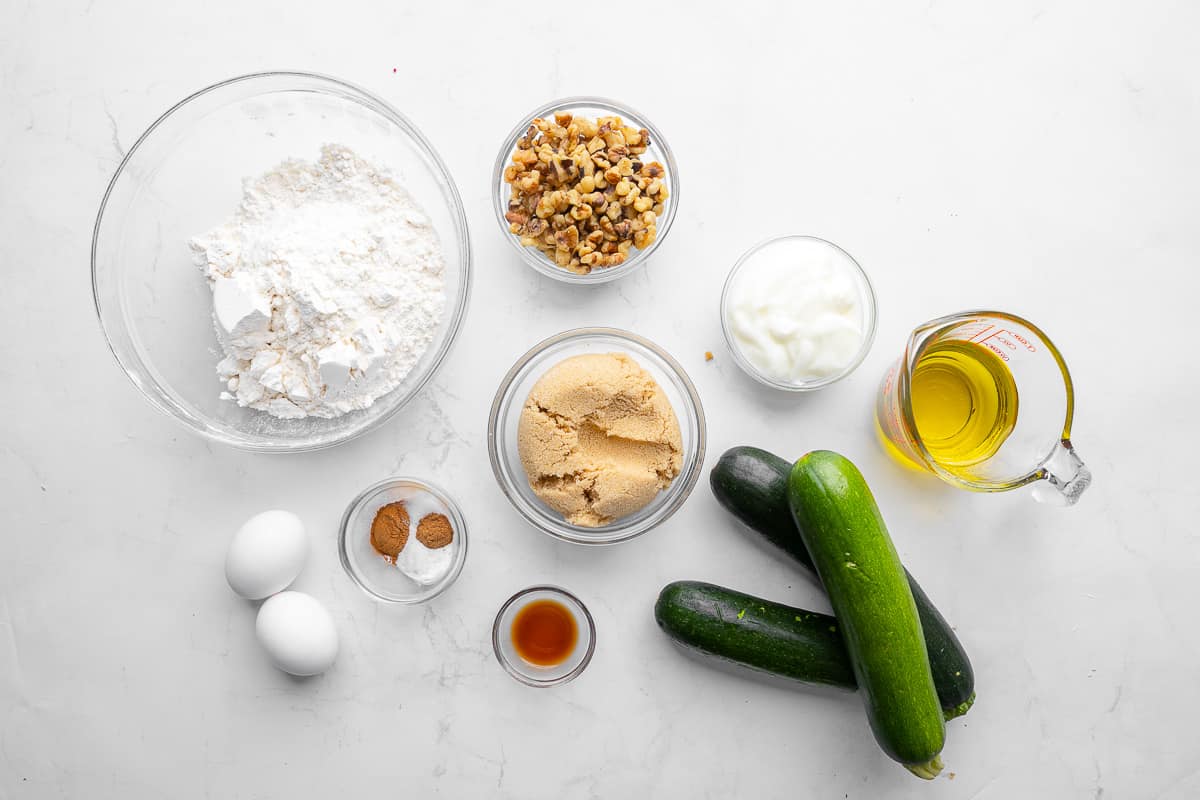 Ingredients for recipe: flour, walnuts, brown sugar, salt, baking powder, cinnamon, and nutmeg, yogurt, oil, and zucchini.