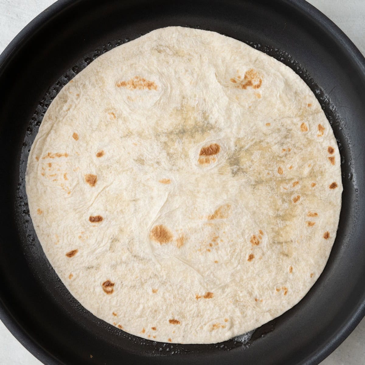One tortilla in pan.
