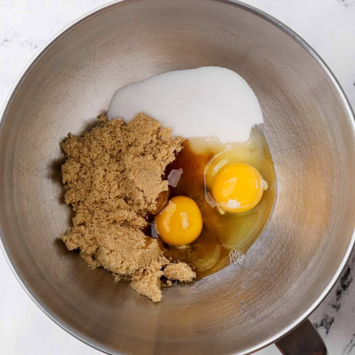 Eggs, brown sugar, and granulated sugar in a bowl.