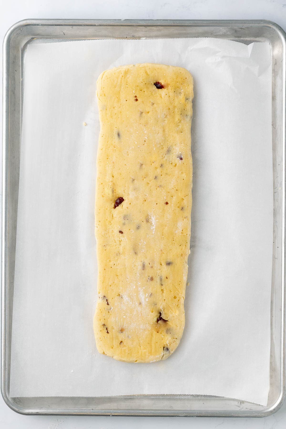 Kneaded dough shaped on parchment paper.