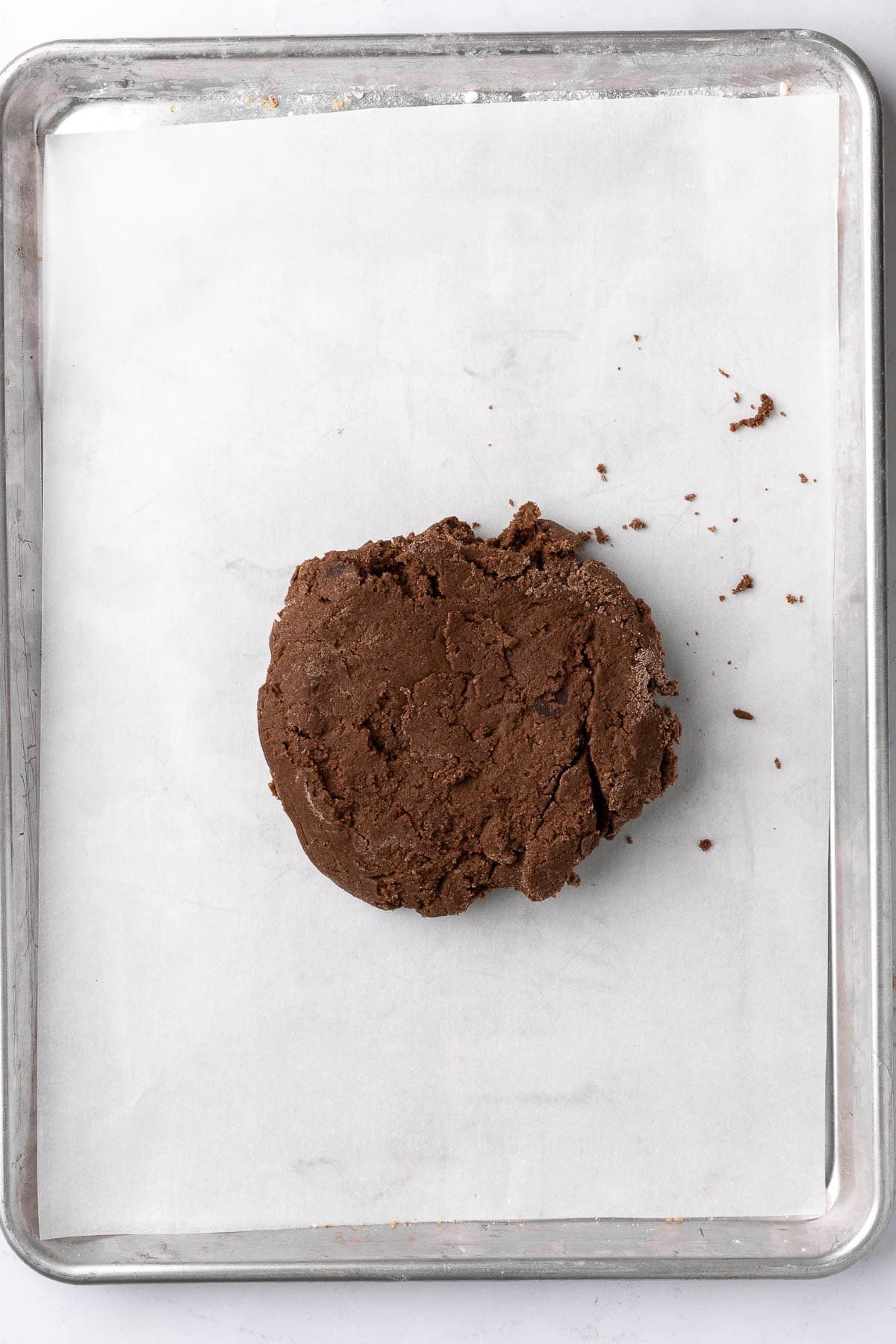 Kneaded dough transferred to parchment paper lined baking sheet before shaped