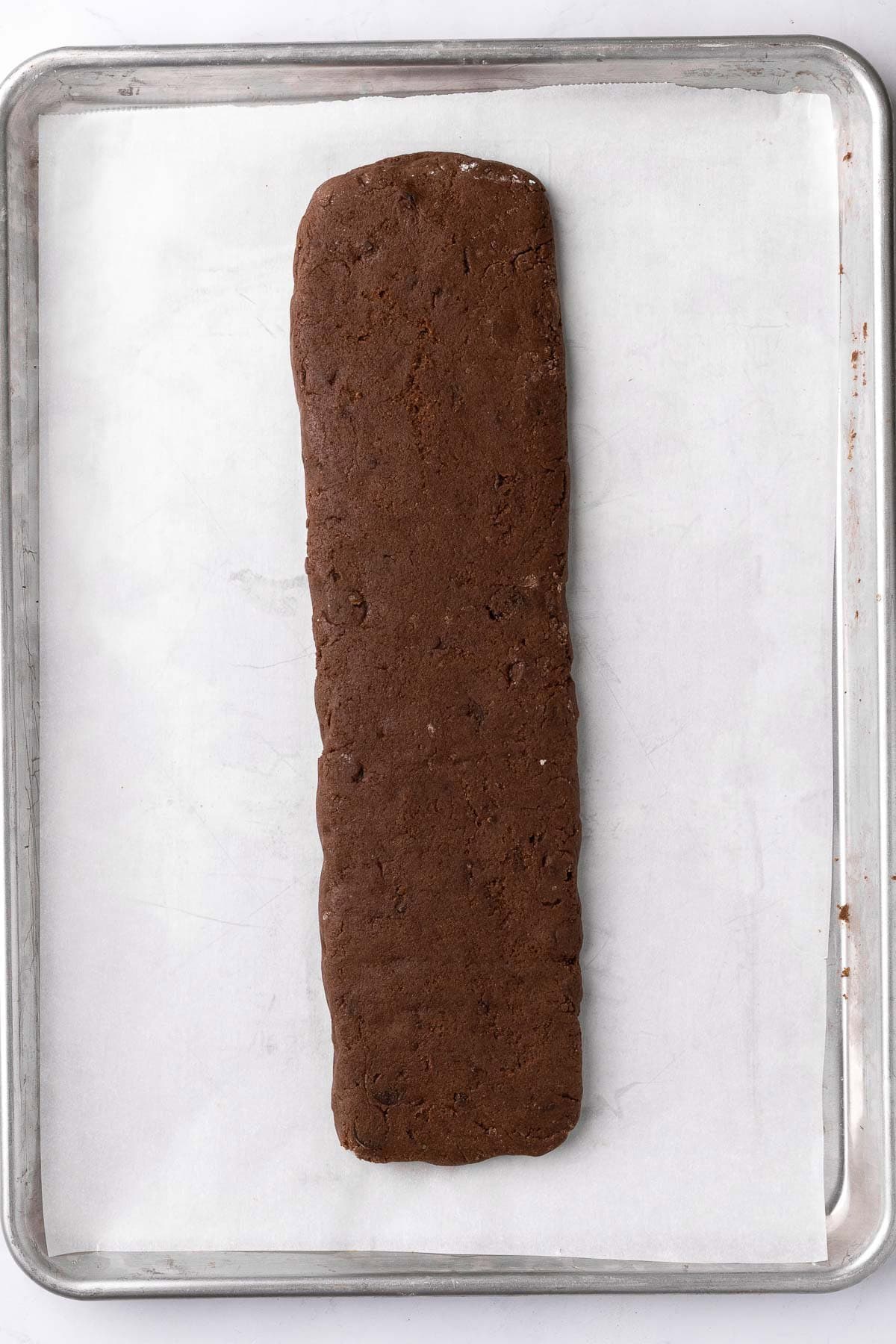 Kneaded dough shaped on parchment paper.