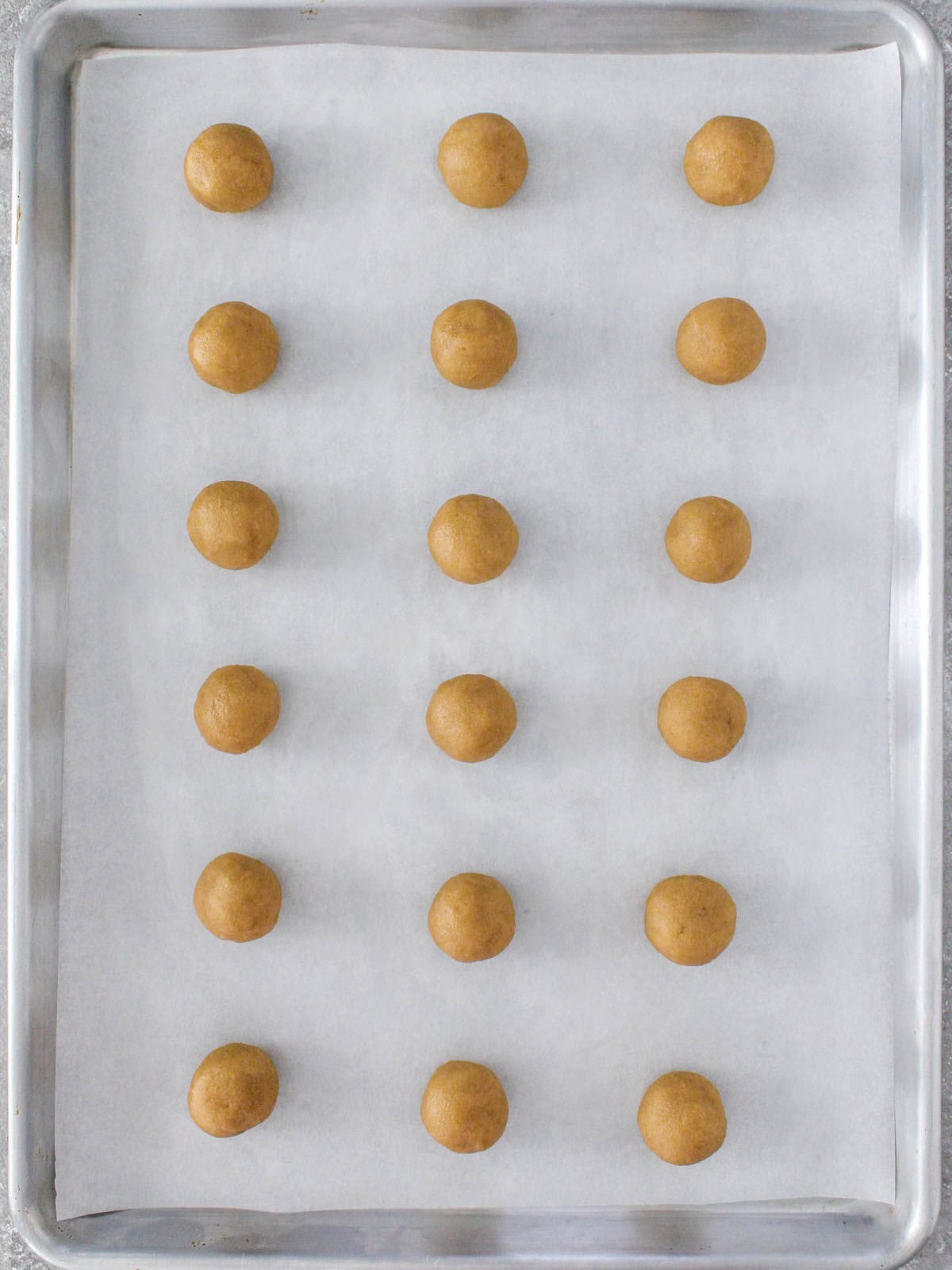 Cookie balls on a baking sheet.