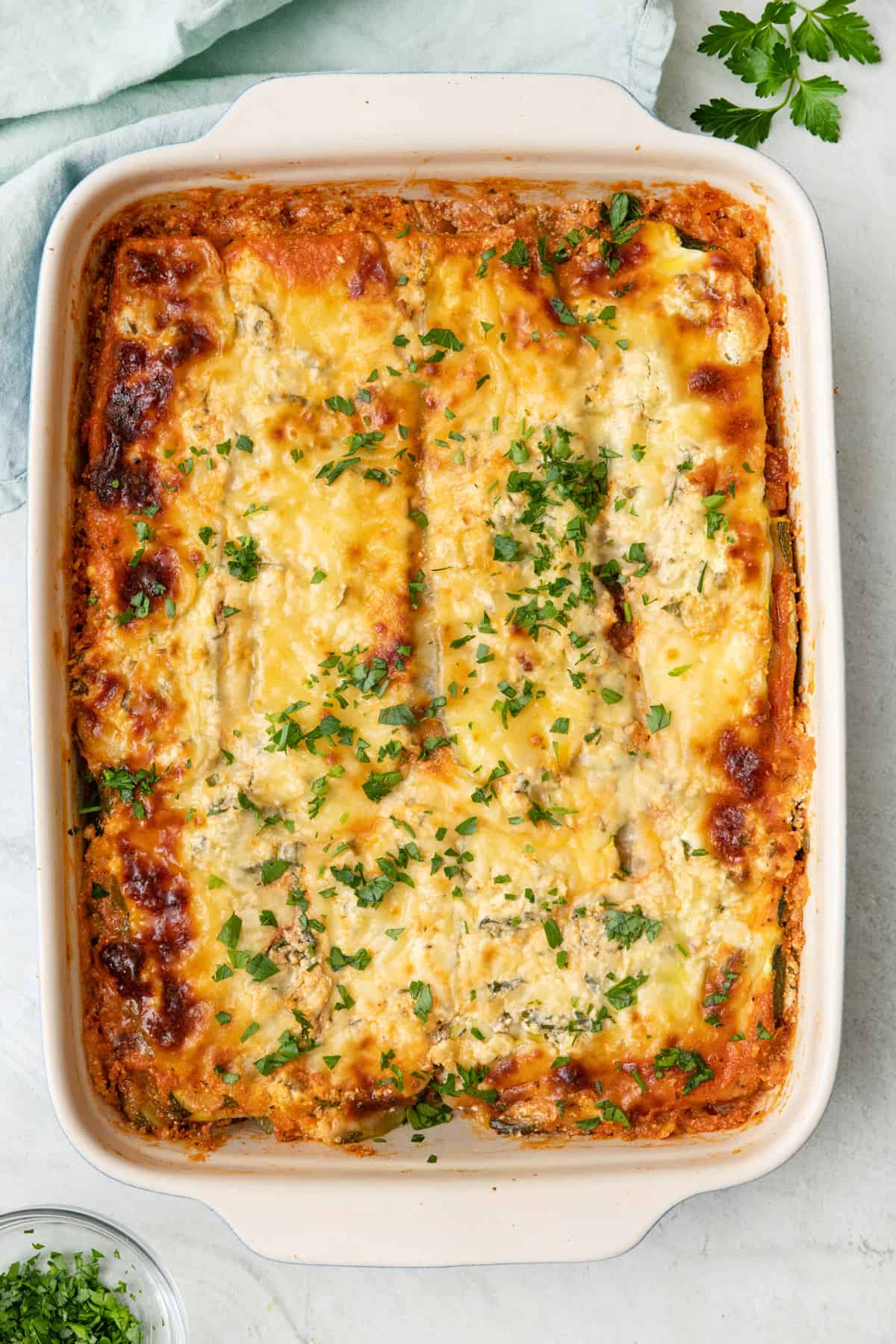 Zucchini Lasagna in a baking dish garnished with fresh parsley.