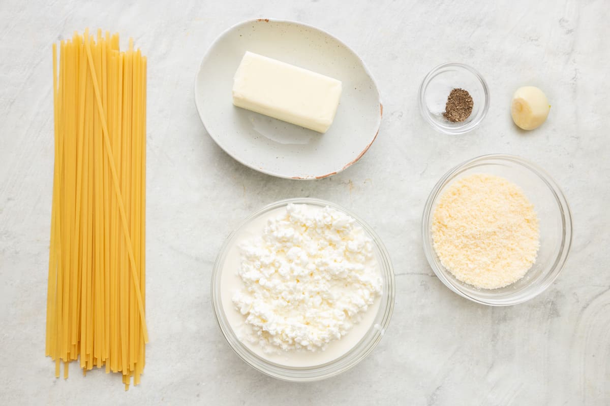 Ingredients for recipe: uncooked linguine, butter, cottage cheese, parmesan, salt, pepper, and a garlic clove.