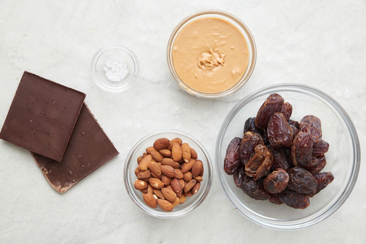 Ingredients for recipe: chocolate bar, salt, almonds, peanut butter, and Medjool dates.