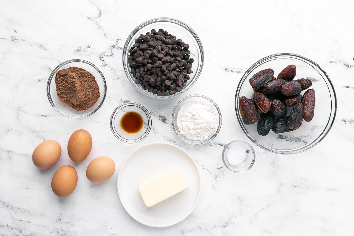 Ingredients for recipe: cocoa powder, eggs, vanilla, chocolate chips, flour, butter, salt, and Medjool dates.