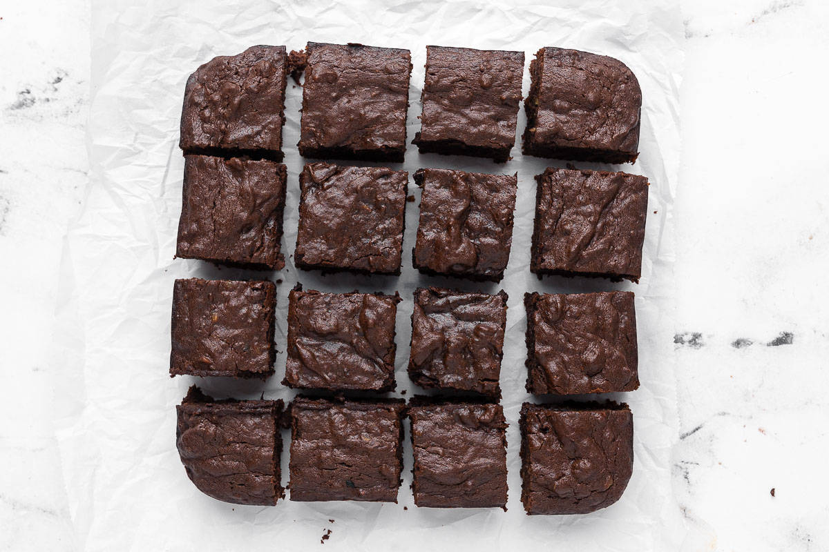 Date brownies on parchment cut into 16 squares.