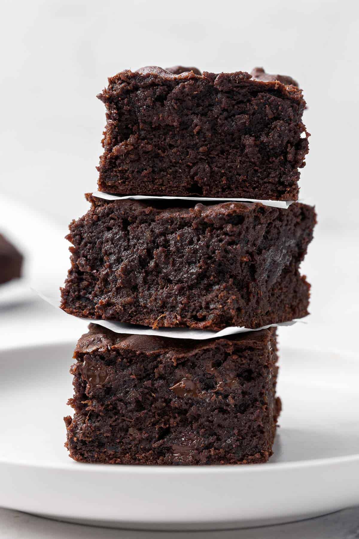 3 date brownie squares stacked on top of eachother with a small piece of paper between each.