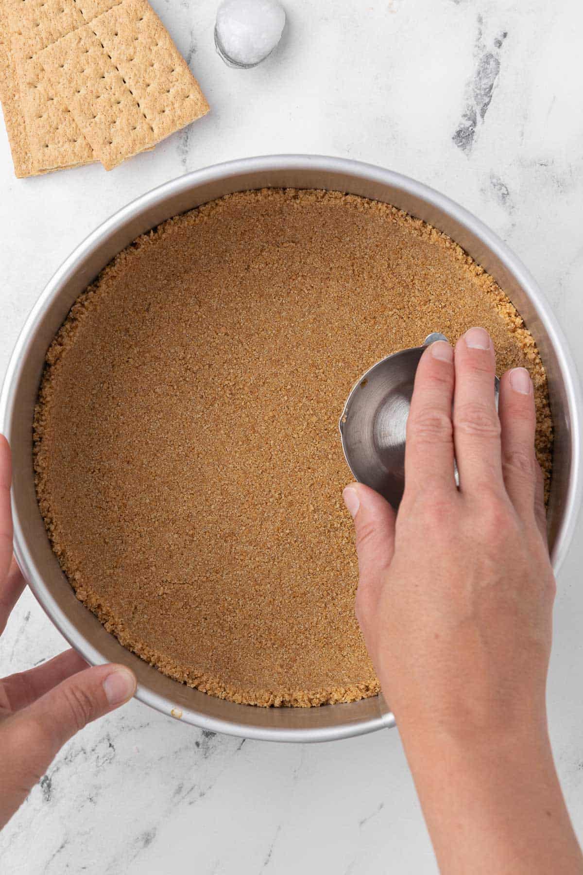 How to make a coconut oil graham cracker crust in a springform pan.