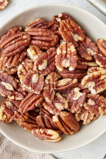 Square image of a bowl of toasted pecans.