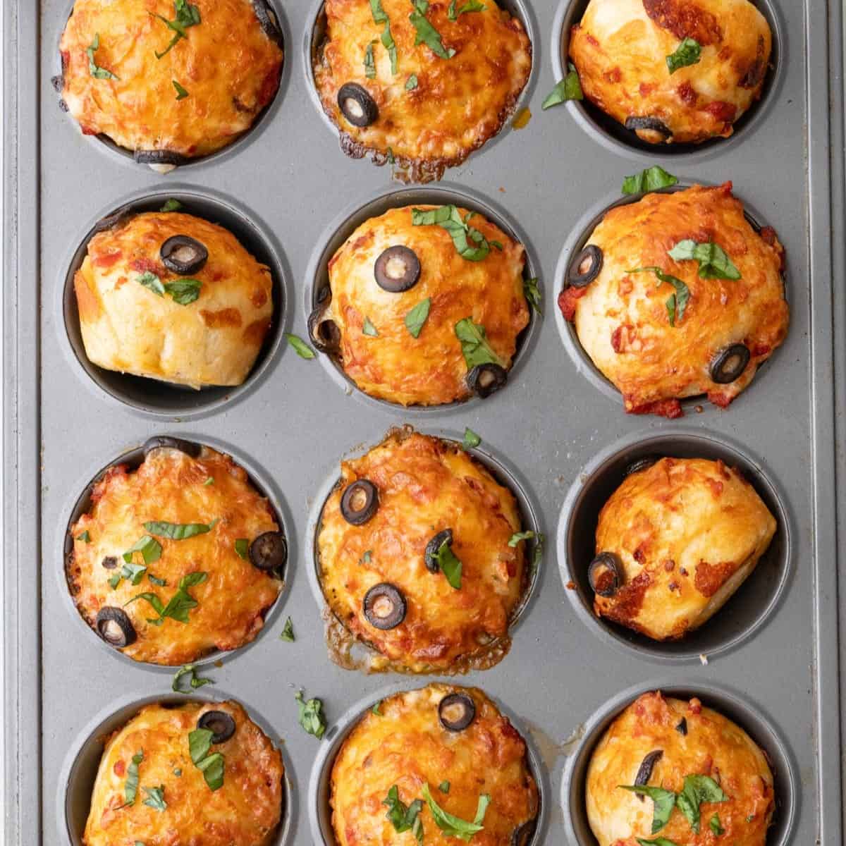 Pizza muffins in muffin pan.
