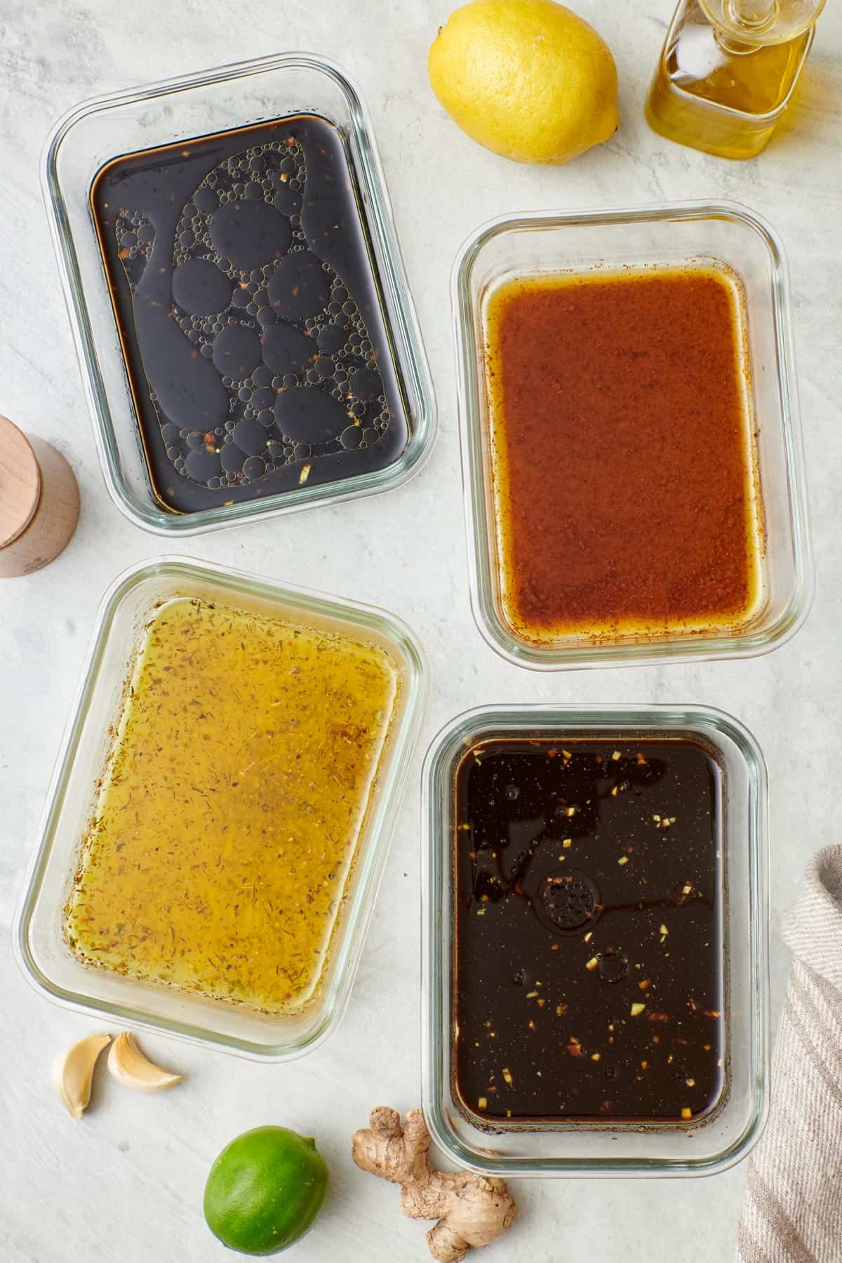 Steak marinade 4 ways in separate dishes: Soy Ginger, Lemony Italian, Cumin Lime, and Garlicky Worcestershire.