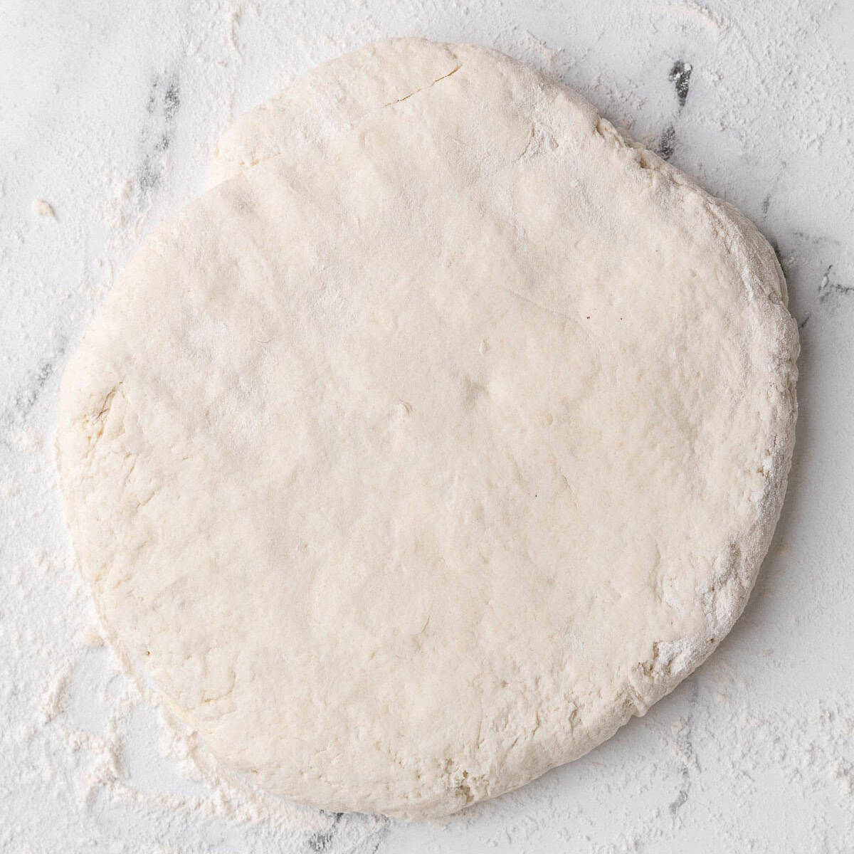 Smooth dough flattened into a disc.