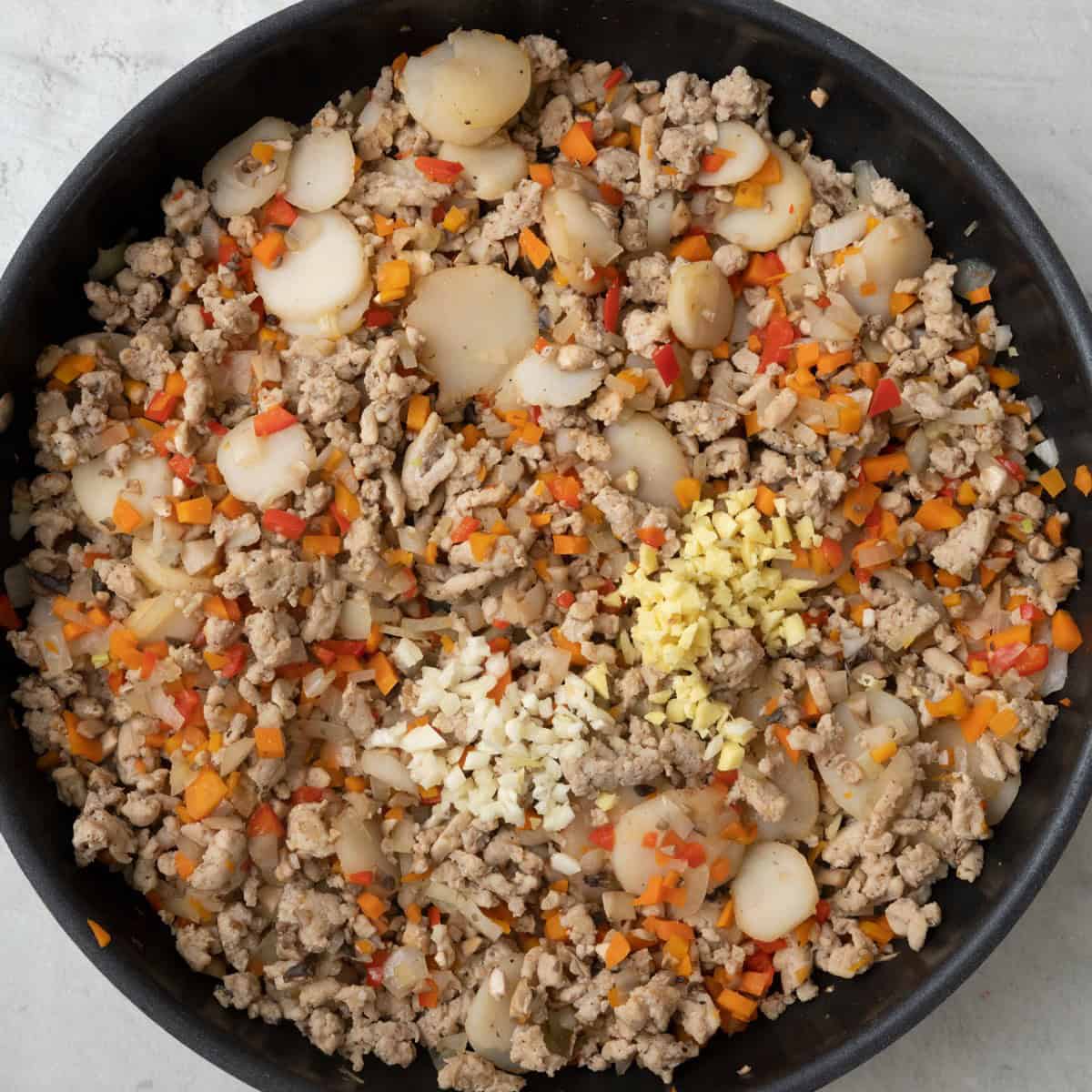 Chicken and veggie mix after veggies are softened with ginger and garlic added.