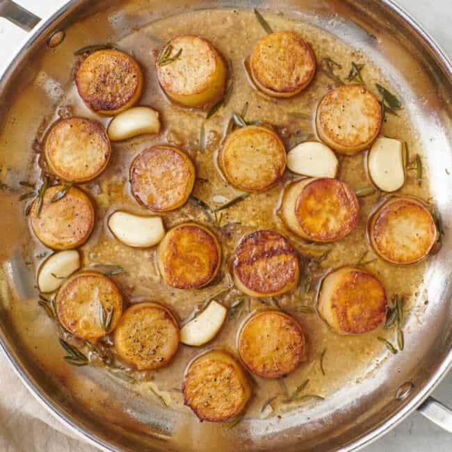 Fondant melting potatoes in skillet.