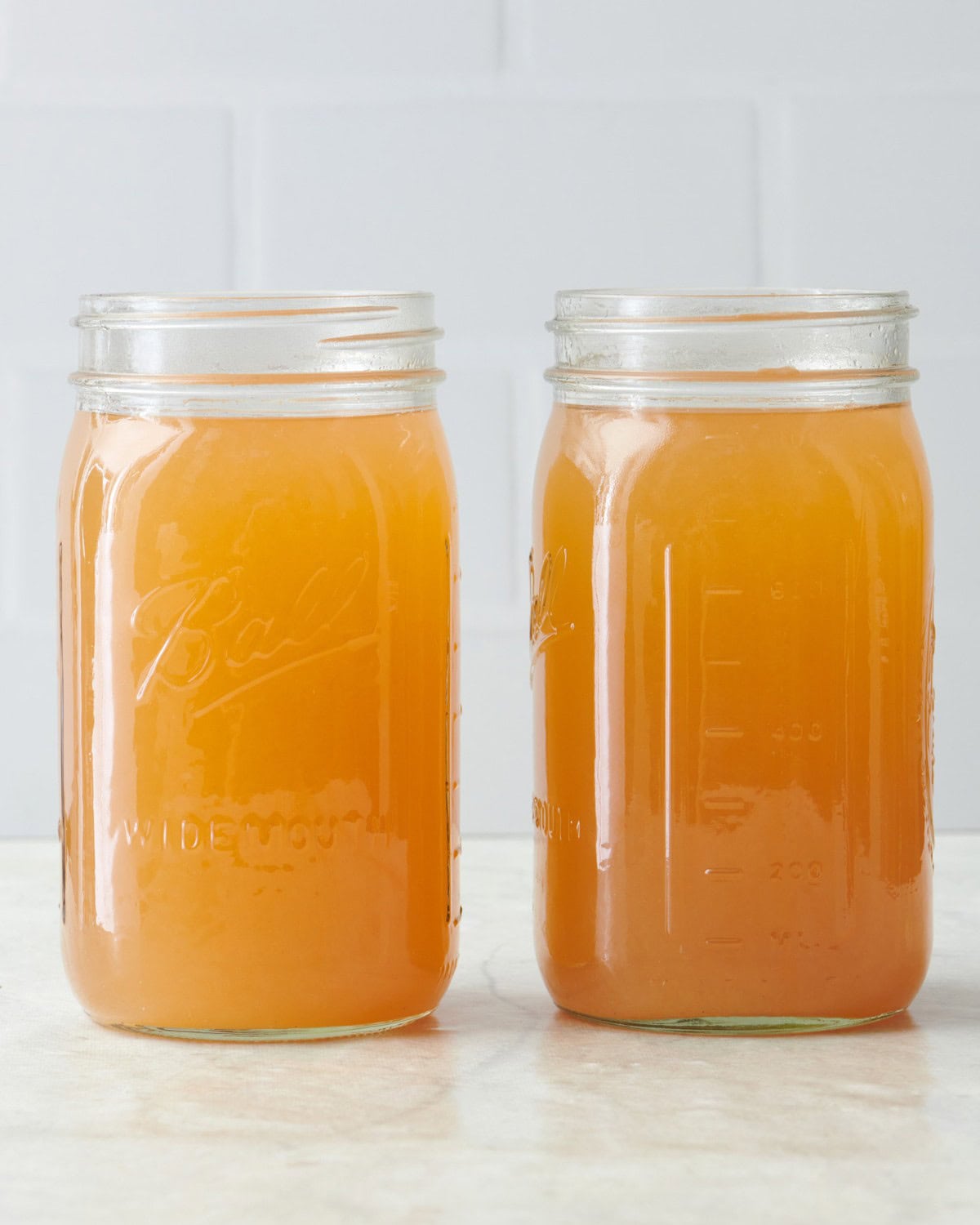 Cider in two clear mason jars after straining.