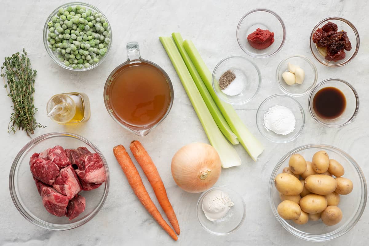 Ingredients for recipe: fresh thyme, frozen peas, oil, beef stew meat, beef broth, carrots, celery, onion, flour, seasonings, tomato paste, sun-dried tomatoes, garlic, Worcestershire sauce, and potatoes.