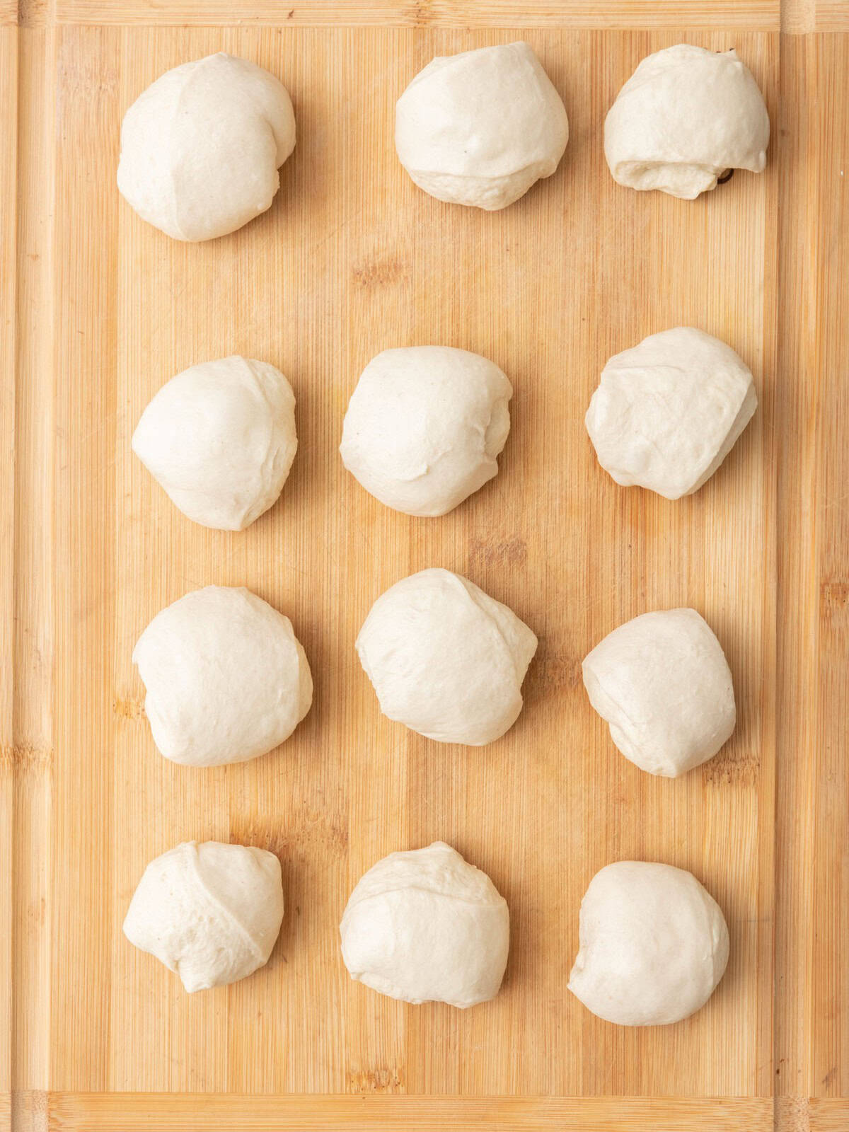 Pizza dough Pizza divided into 12 balls on flat surface.