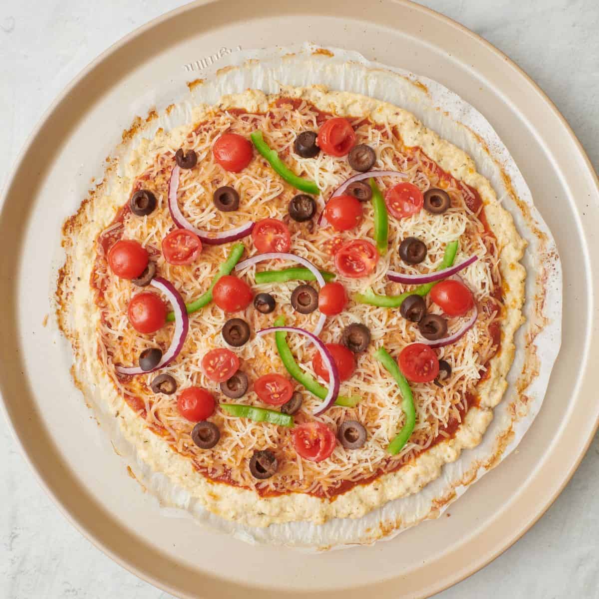 After baking with sauce, cheese, and veggie toppings added before baking again.