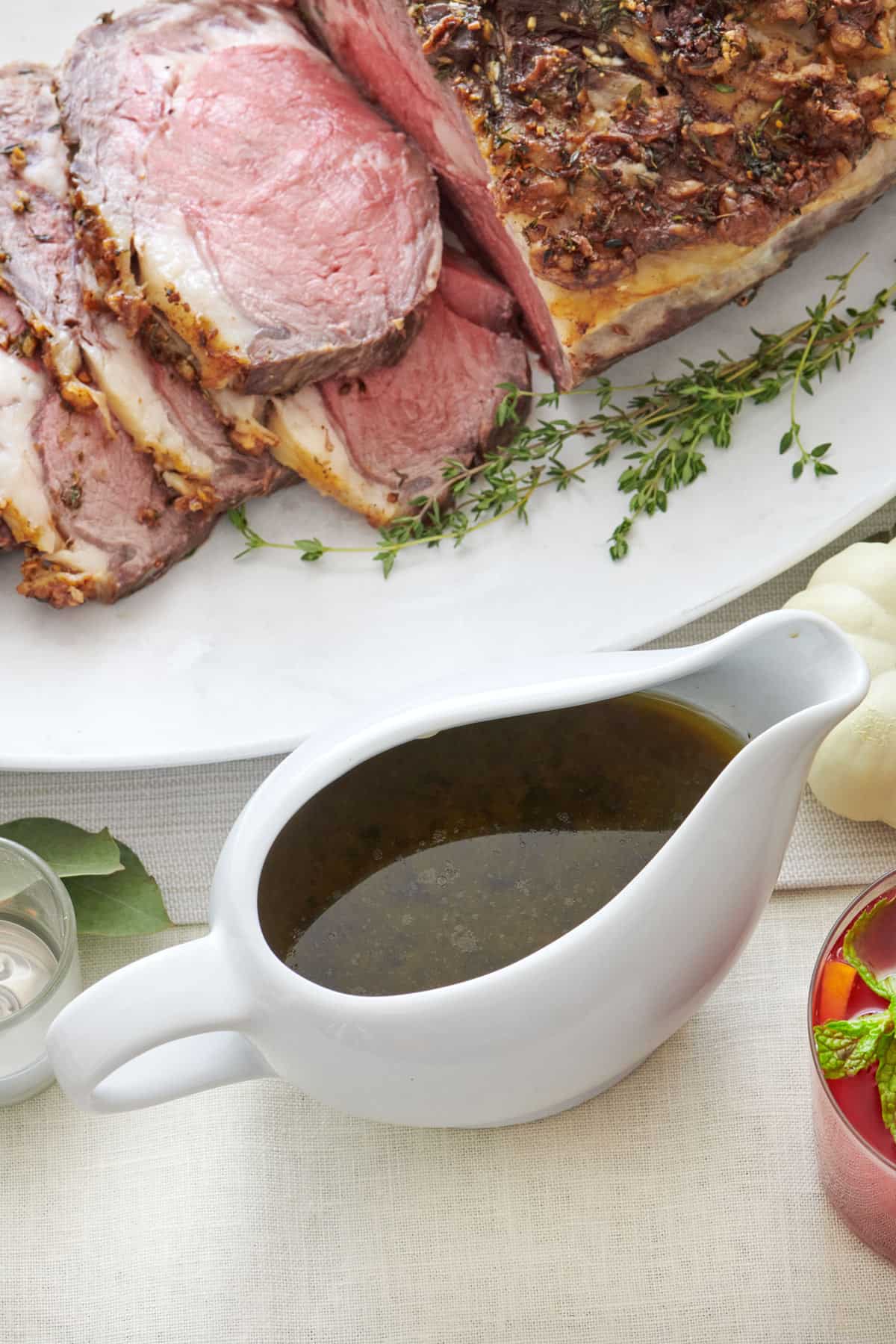 Au jus in a gravy boat next to prime rib.