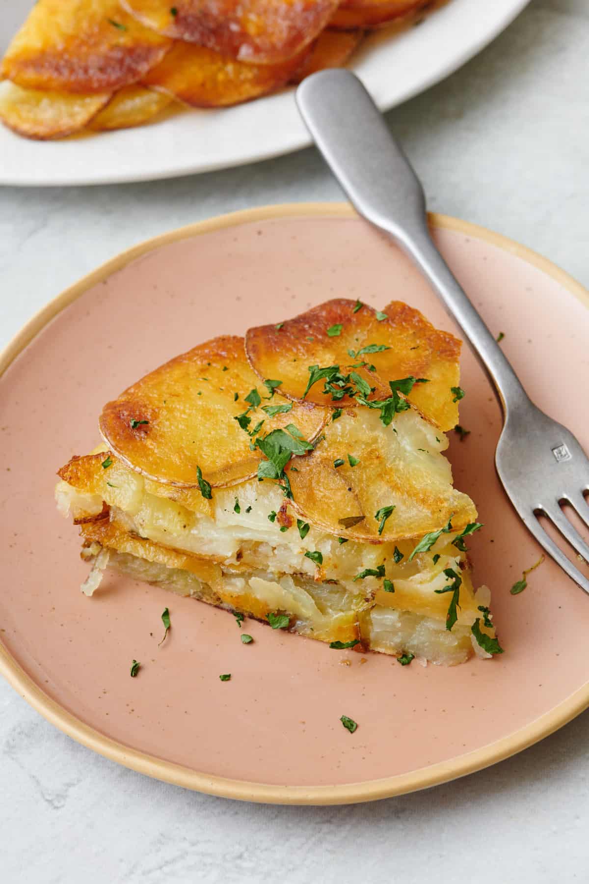 Serving of potato galette on a plate with fork.