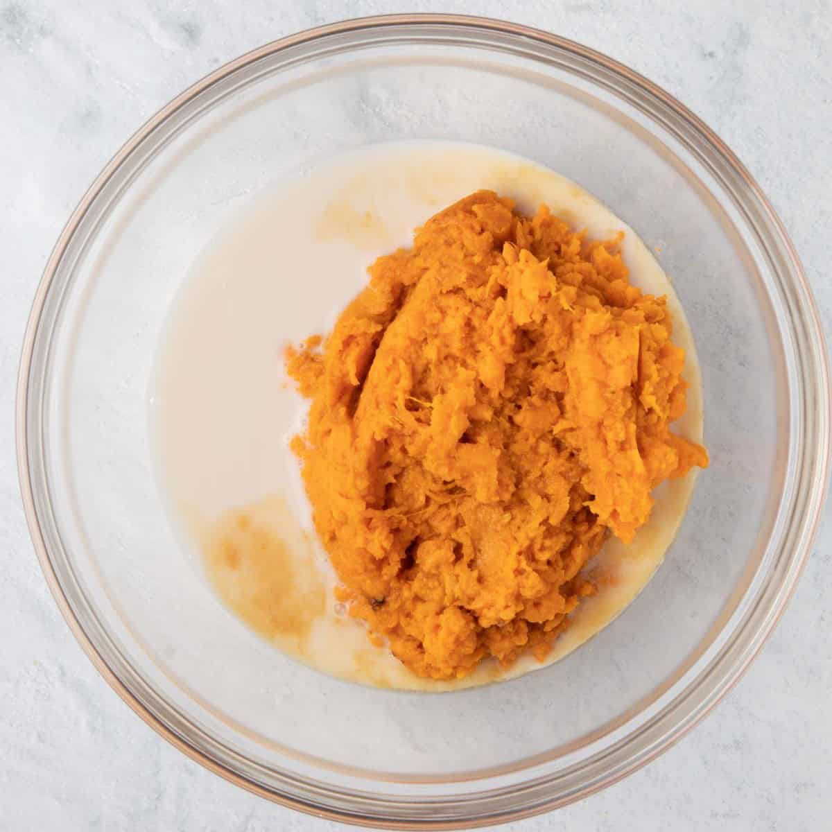 Sweet potatoes, almond milk, and vanilla in a bowl before combining.
