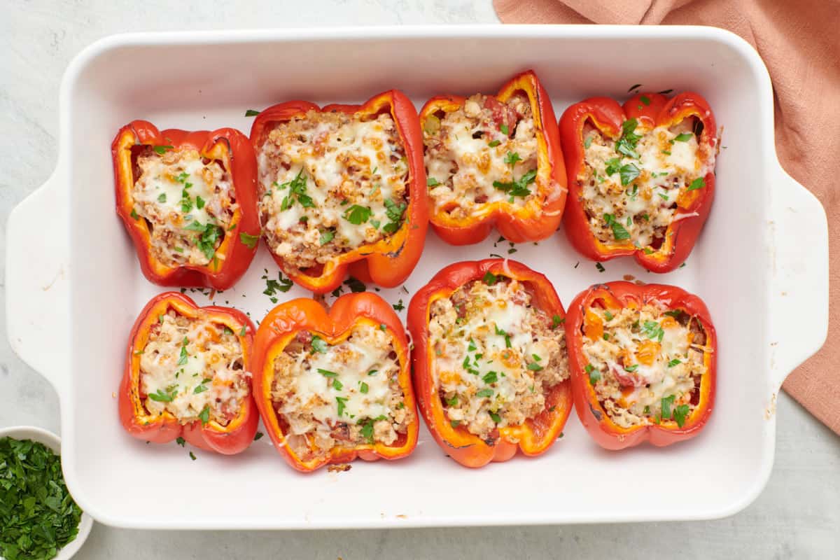 Turkey stuffed peppers in baking dish, garnished with fresh parsley.