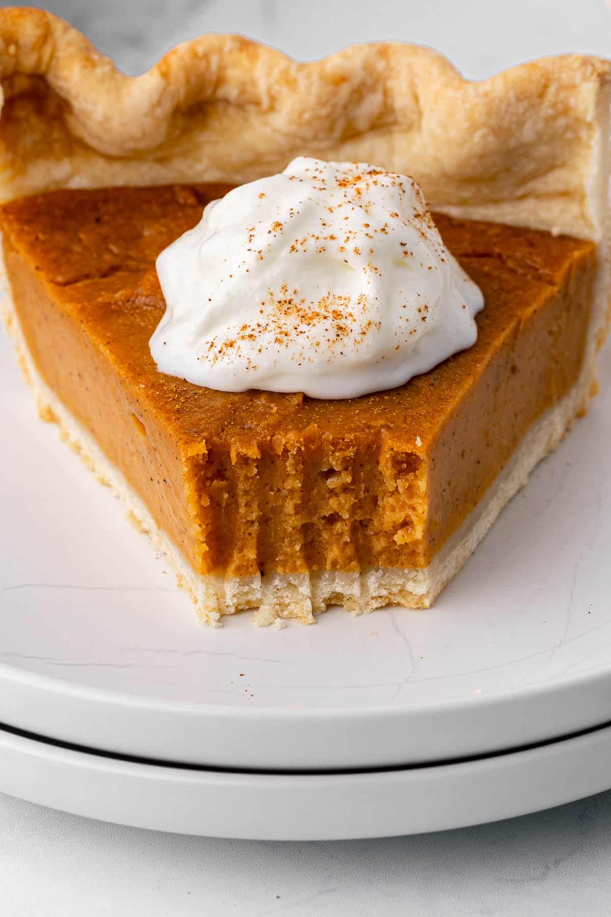 Close up of sweet potato pie with a fork bite taken out to show texture.